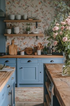 a kitchen with blue cabinets and floral wallpaper