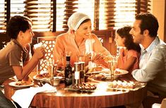 a group of people sitting around a table eating food