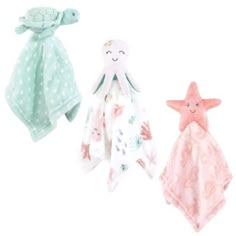 three towels and two stuffed animals are on the white background, one is pink and one is green