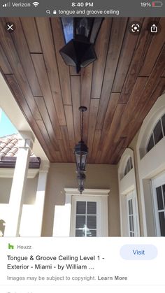 a light hanging from the side of a wooden ceiling next to a white door and windows