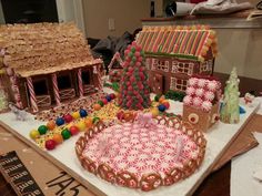 gingerbread houses are decorated with candy and candies on a table in the kitchen