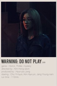 a woman with glasses standing in front of a sign that says warning do not play