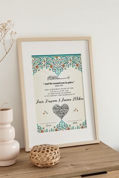 an ornate frame with a heart on it next to a vase