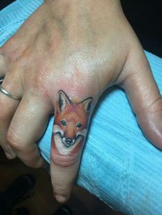 a woman's hand with a fox tattoo on it