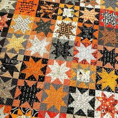 an orange and black quilt with stars on it