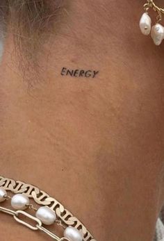 a woman's neck with the word energy written on her left side ribcage