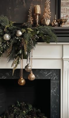 a mantel decorated with greenery, ornaments and gold baubes for christmas