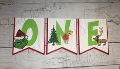 christmas banner hanging on the side of a wooden wall with one word written in green and red