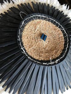 a black and white fan with some blue pins in it's center, sitting on a table