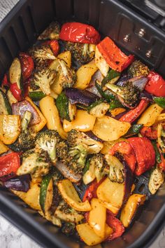 a container filled with assorted veggies sitting on top of a stovetop