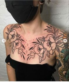 a woman wearing a black mask with flowers on her chest