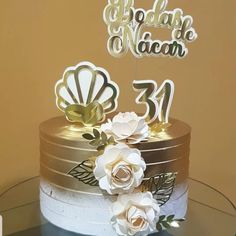 a three tiered cake with white flowers on top and the number twenty two in gold