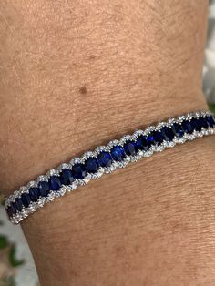 "Gorgeous Sapphire and Diamond Bracelet. The blue sapphires are a deep blue color with lots of life to them; all well matched. All REAL stones. You can tell it's blue right away, unlike some sapphires that are so dark they look black. Excellent craftsmanship, the row of blue sapphires are framed on each side by a scalloped row of sparkling diamonds. All stones are set smooth. The lock is easy to work and very secure with safety latch. The width measures 7mm. Will fit 7\" wrist comfortably. One O Luxury Sapphire Bracelets, Round Sapphire Bracelet, Luxury Round Sapphire Bracelet, Sapphire Tennis Bracelet With 17 Jewels, Luxury Sapphire Gemstone Tennis Bracelet, Luxury Sapphire Tennis Bracelet With Brilliant Cut, Luxury Sapphire Round Bracelets, Sapphire Bracelets With Prong Setting For Anniversary, Fine Jewelry Sapphire Bracelets