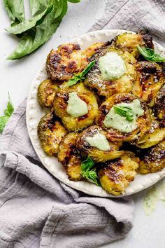 grilled brussels sprouts with lemon - tahini sauce on a white plate