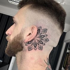 a man with a flower tattoo on his neck