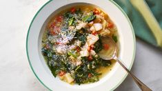 a white bowl filled with soup on top of a marble counter next to a green towel