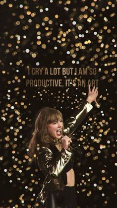 a woman singing into a microphone in front of a background with lights and sparkles