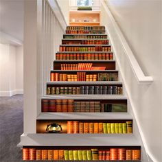 the stairs are lined with books and there is also a light on top of them