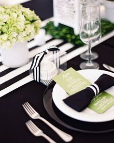 an image of a table setting with black and white plates, napkins and silverware