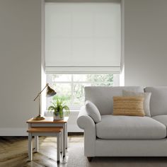 a living room with a white couch and wooden coffee table in front of the window