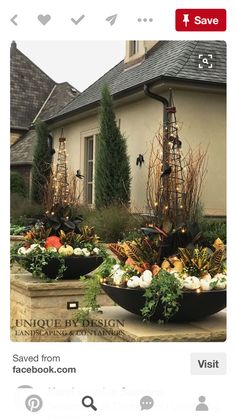 two large black bowls filled with vegetables in front of a house that is decorated for halloween