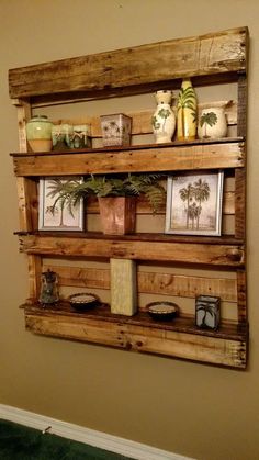 a wooden shelf with pictures and candles on it