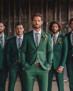 a group of men in green suits and ties posing for the camera with their hands in their pockets