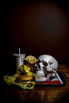 there is a skull and some food on the table with a drink in front of it