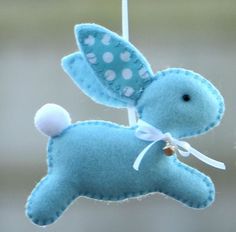 a blue stuffed animal hanging from a string with polka dots on it's ears