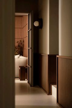 an open door leading to a bedroom with a bed in the corner and a plant on the wall