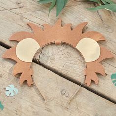 a paper cut out of the shape of a sun with leaves around it on a wooden surface