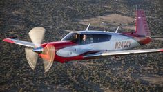 a small airplane flying through the air over land