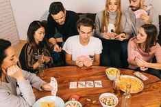 a group of people playing cards at a table with chips and chips in front of them