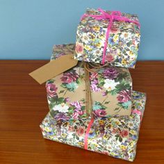 three wrapped presents sitting on top of a wooden table