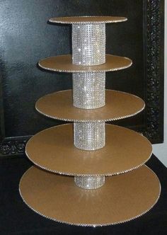 three tiered cake stand in front of a black wall with a mirror behind it