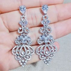 Elegance, sparkle and fluid motion define this exquisite pair of bridal earrings. All it takes is a simple glance at this unique design to see its extremely classy look that will add glamour and sophistication to any bridal gown or formal ensemble. Length: 2" (approx. 5cm); Width: 1" (approx. 2.3cm); Weight: 12g Choose between Rose Gold, Silver and Yellow Gold finishes. To make your choice select from the dropdown menu. Hypoallergenic - lead, nickel and cadmium free. Glamorous Diamond Earrings With Elegant Design For Wedding, Glamorous Wedding Diamond Earrings With Elegant Design, Diamond White Elegant Bridal Earrings For Party, Glamorous Sparkling Diamond Wedding Earrings, Glamorous Sparkling Diamond Earrings For Wedding, Elegant Cubic Zirconia Bridal Earrings For Evening, Elegant Diamond Crystal Earrings For Wedding, Glamorous Drop Diamond Earrings For Wedding, Dazzling Crystal Bridal Earrings With Elegant Design