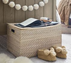 there is a basket with books and stuffed animals on it next to a pair of slippers