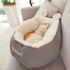 a cat laying in a bed on top of a couch