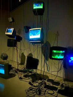 several televisions are connected to wires and plugged into the wall in an art gallery