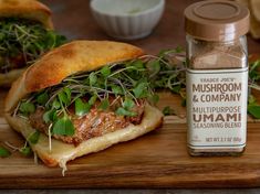 a sandwich on a cutting board next to a jar of mushroom and company seasoning blend