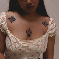 a woman with tattoos on her chest wearing a white dress