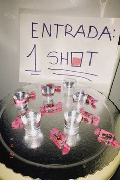 a sign that says entrada 1 shot on top of a cake with cups