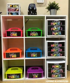 there are many bins on the shelf with words painted on them, and one is for each child's name