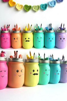 there are many painted mason jars with pencils in them