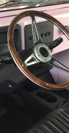 the steering wheel and dashboard of an old car with wood grained dash tape on it