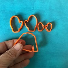 someone is holding out some cookie cutters to make something look like they are in the shape of a heart