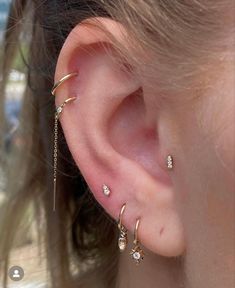 a close up of a person's ear with three different piercings on it