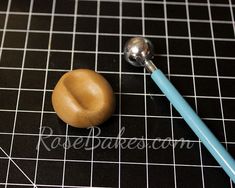 a blue toothbrush sitting on top of a table next to a wooden ball and spoon