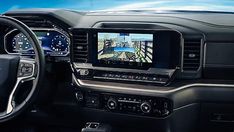 the interior of a car with an entertainment system and steering wheel controls, including gps