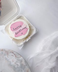 a birthday cake sitting on top of a white plate next to a container of milk